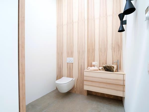 Gäste-WC mit Holzoptik und Natursteinwaschbecken