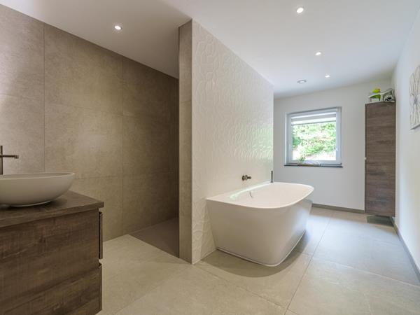 Hochwertiges Badezimmer mit Badewanne und 3D-Blattfliesen