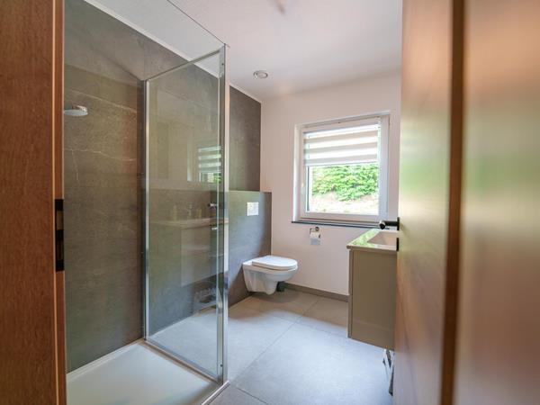 Badezimmer mit begehbarer Dusche und Steinoptik-Fliesen