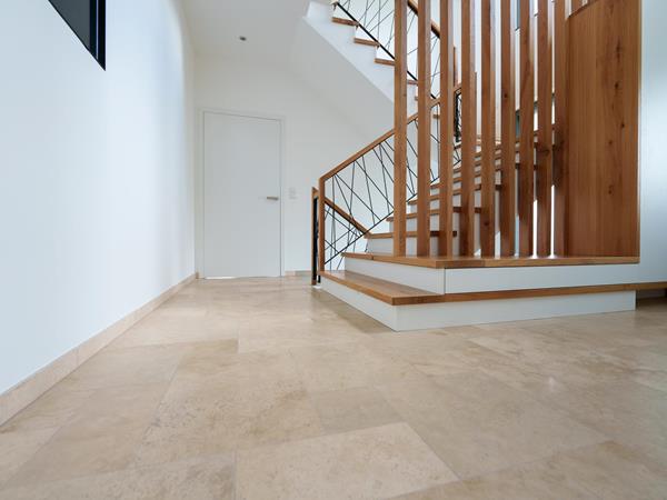 Eingangsbereich mit Natursteinfliesen und Holztreppe